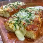 Delicious homemade cheesy garlic bread with melted cheese and herbs