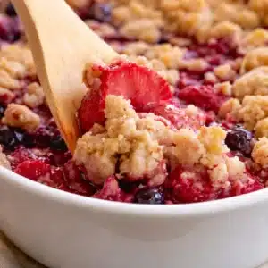 Easy gluten free fruit crumble served warm with a golden brown topping.