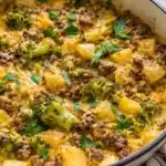Gluten free beef and potato skillet dinner in a cast iron pan with vibrant ingredients.