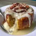 Gluten free cinnamon roll in a mug topped with icing