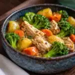 Gluten free baked chicken accompanied by colorful roasted vegetables.