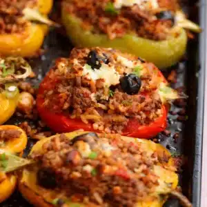 Gluten free stuffed bell peppers filled with beef, rice, and vegetables, served on a plate.