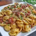 Creamy vegan sun-dried tomato pasta served in a bowl with fresh basil
