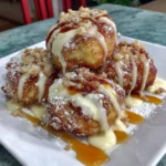 Gluten-free apple fritters stacked on a plate with a sprinkle of powdered sugar.