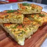 Gluten-free focaccia bread with garlic and herbs, perfect for gut health.