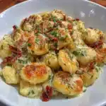 Plate of gluten-free potato gnocchi garnished with fresh herbs