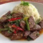 Plate of Mongolian Beef served with vegetables and rice
