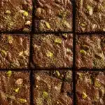 Gluten free pistachio protein brownies topped with crushed pistachios and chocolate.