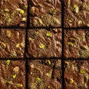 Gluten free pistachio protein brownies topped with crushed pistachios and chocolate.