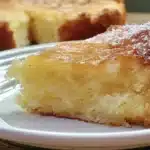 Gluten-free French butter cake topped with fresh berries on a white plate