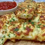 Gluten free garlic pizza breadsticks on a wooden platter