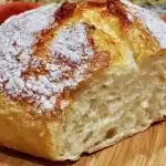 Slice of freshly baked no knead gluten free bread on a wooden table