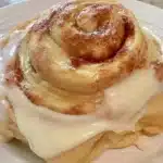 Gluten-free cinnamon rolls drizzled with sweet icing on a plate