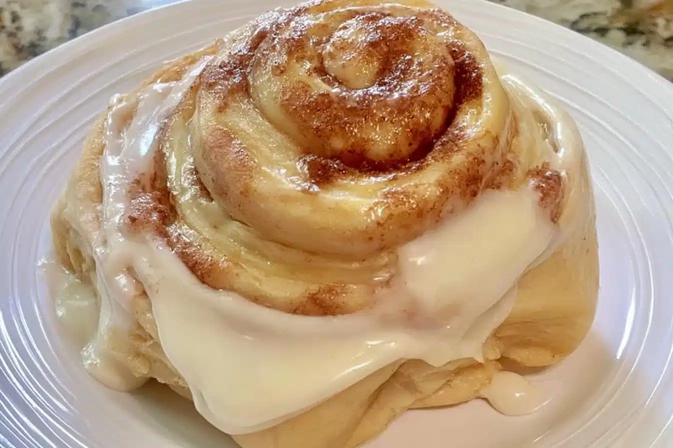 Gluten-free cinnamon rolls drizzled with sweet icing on a plate