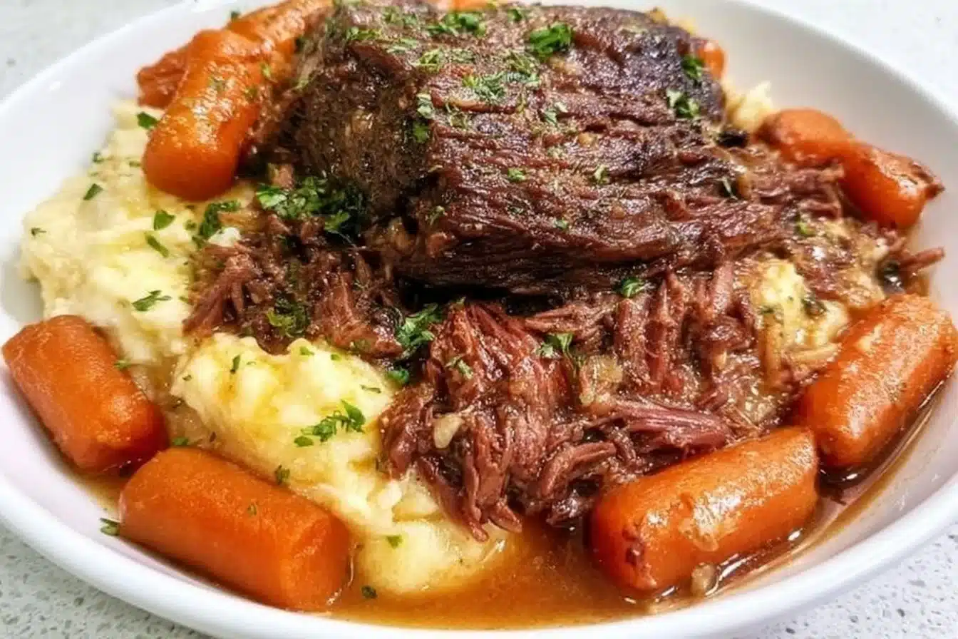 Slow cooker garlic herb pot roast served with vegetables in a rustic dish.