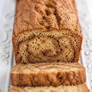 Sliced Cinnamon Swirl Zucchini Bread on a wooden board, gluten-free and dairy-free