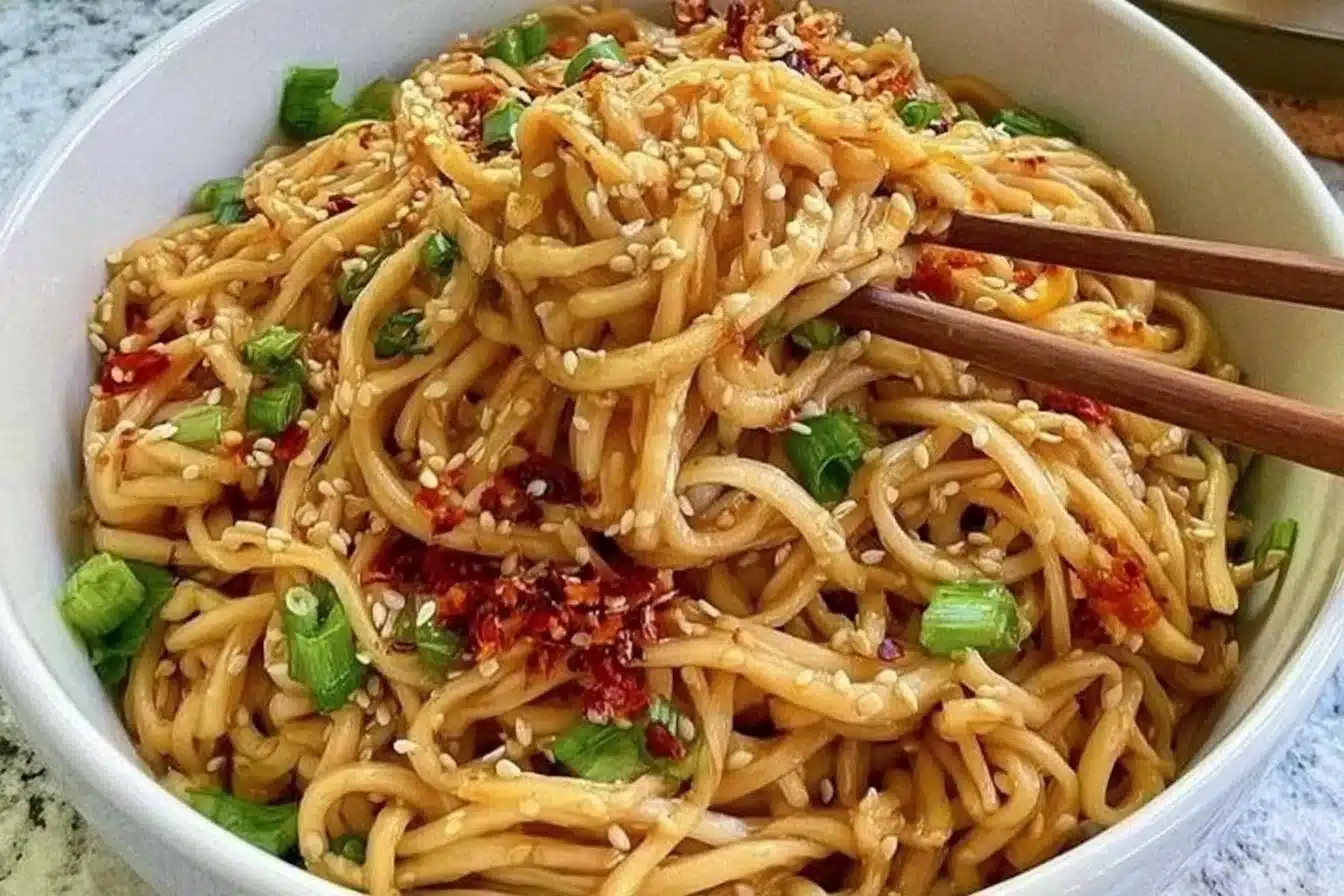 Delicious bowl of Garlic Sesame Noodles topped with sesame seeds and green onions