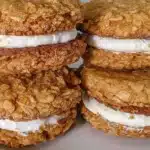 Gluten-free homemade oatmeal cream pies stacked beautifully on a plate.