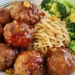 Honey ginger meatballs served on a plate with a side of vegetables