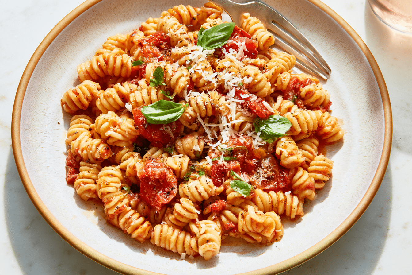 A close-up shot of creamy gluten-free yogurt pasta in a bowl, garnished with fresh herbs, ready to be eaten. The pasta should look perfectly coated in the rich, white sauce.