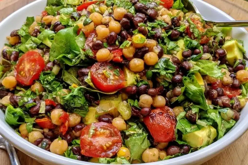 Bowl of colorful Southwest Chickpea Black Bean Salad with veggies and dressing